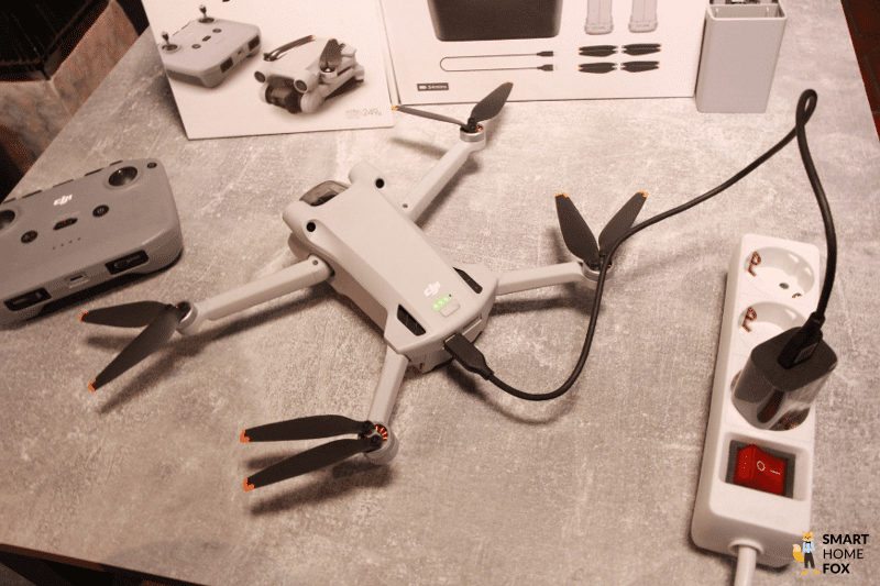 Ein Akku wird in der DJI Mini 3 Pro per USB-C-Kabel geladen.